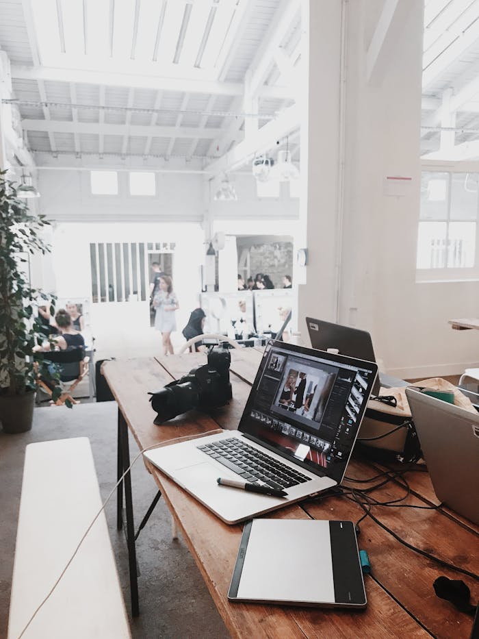 why-choose-us A bright, modern workspace featuring laptops, a camera, and a drawing tablet in an indoor office.